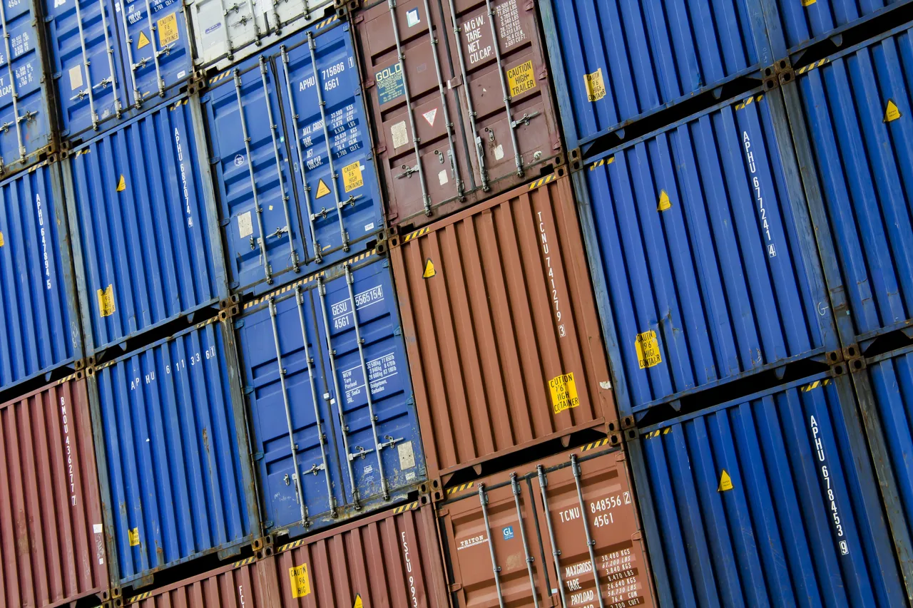 Blue and rust-coloured freight containers stacked at the Port of Rotterdam
