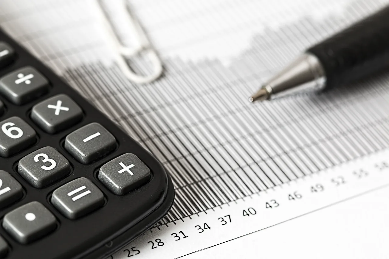 A calculator, pen and financial figures illustrating a careful review of commercial details